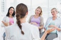 Pregnant women listening to gesturing doctor at antenatal class