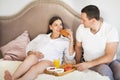 Pregnant woman and man having breakfast with orange juice and cr