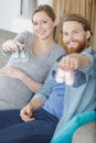 Pregnant woman and man holding baby shoes Royalty Free Stock Photo