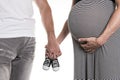Pregnant woman and man holding baby shoes Royalty Free Stock Photo