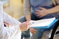 Pregnant woman sign the contract or permit during accepts of gynecologist doctor. Medical insurance childbearing. Family doctor