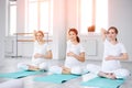 Pregnant women sitting on exercise mat and touching belly