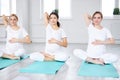 Pregnant women sitting on exercise mat and touching belly