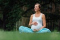 Pregnant yoga woman with mat portrait in park on the grass, breathing, stretching, statics. outdoor, forest. Royalty Free Stock Photo