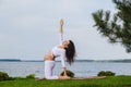 Pregnant woman is practicing yoga beside river Royalty Free Stock Photo