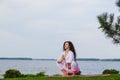 Pregnant woman is practicing yoga beside river Royalty Free Stock Photo