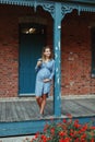 Pregnant young Caucasian woman wearing long blue dress and rustic country hat in park outside. Royalty Free Stock Photo