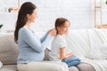Pregnant young mother combing her little daughter hair Royalty Free Stock Photo
