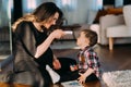 Pregnant mother taking child temperature with digital thermometer, coronavirus prevention