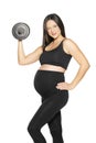 A pregnant young woman in black leggings and a hirt posing with weights