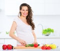 Pregnant young woman cooking vegetables Royalty Free Stock Photo