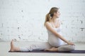 Pregnant young woman doing prenatal yoga. Spinal twist in Janu S