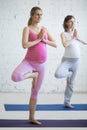 Pregnant young woman doing prenatal yoga. Tree pose Royalty Free Stock Photo