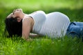 Pregnant young woman lying on the grass Royalty Free Stock Photo