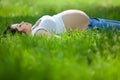 Pregnant young woman lying on the grass Royalty Free Stock Photo