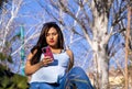 Pregnant young woman in park looking at cell phone Royalty Free Stock Photo