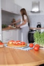 Pregnant young woman preparing healthy sandwiches with microgreens and vegetables at home in the kitchen Royalty Free Stock Photo