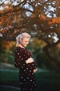 Pregnant young woman on second trimester posing in sunny garden