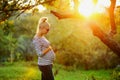 Pregnant young woman on second trimester posing in sunny garden