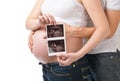 Pregnant young woman showing ultrasound picture of baby Royalty Free Stock Photo