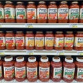 Prego Italian sauce jars with various flavors stacked on supermarket shelves.