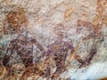 Prehistoric painting of men in actions on rock painted with red colour by human who live in the area over thousand year ago Royalty Free Stock Photo