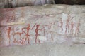 Prehistoric painting by primitive local caveman on the stone wall showing the hunting and civilization over 4000 years, Thailand