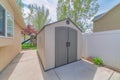 Premade shed in the backyard by the buildings and trees under the sunlight