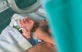 Premature newborn baby inside a covered incubator