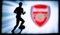 LONDON, ENGLAND, JULY. 1. 2019: Arsenal Football club logo, Premier League, England. Soccer player silhouette Royalty Free Stock Photo