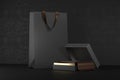 Premium black package for purchases on a black background. Black paper shopping bag with handles Mock Up. Luxury bag and Royalty Free Stock Photo