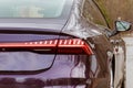 Premium LED sedan taillights. The car is purple in the street. close-up
