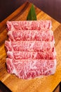 Premium Rare Slices Wagyu A5 beef with high-marbled texture on square wooden plate served for Sukiyaki and Shabu