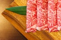 Premium Rare Slices Wagyu A5 beef with high-marbled texture on square wooden plate served for Sukiyaki and Shabu