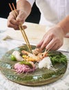 Premium Sashimi prepared by chef, Garnished with edible flowers in green ceramic plate on wooden background Royalty Free Stock Photo