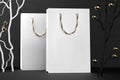 Premium white shopping bags mock-up, package for purchases on a black background. White paper shopping bag with golden handles Royalty Free Stock Photo