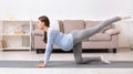 Athletic pregnant girl doing rear leg raise exercises