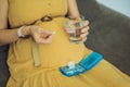 Prenatal Vitamins. Portrait Of Beautiful Smiling Pregnant Woman Holding Pill Box and a glass of water, Taking Royalty Free Stock Photo