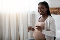 Prenatal vitamins. Pregnant black woman holding supplement pill and glass of water Royalty Free Stock Photo