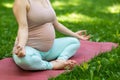 Prenatal yoga. Caucasian pregnant woman doing butterfly pose in the park. Royalty Free Stock Photo