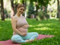 Prenatal yoga. Caucasian pregnant woman doing butterfly pose in the park. Royalty Free Stock Photo