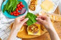 Preparation of all the ingredients for making a burger - bun, cutlet, cheese, salad, tomato, sauces. The girls hands take a burger Royalty Free Stock Photo