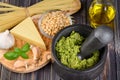 Preparation of basil pesto sauce with the main ingredients: fresh basil leaves, parmesan cheese, pine nuts, garlic Royalty Free Stock Photo