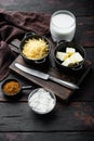 Preparation of bechamel cheese white sauce, on old dark wooden table background
