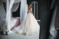 Preparation of the bride on a wedding day. Beautiful brunette girl in a white luxury dress, with earrings, make-up and Royalty Free Stock Photo