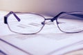 Preparation of business report. A pile of documents, a notebook and glasses on the table