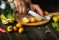 Preparation of canned vegetable salad. Chef hands cut tomatoes on a cutting board with a knife. Peasant food Royalty Free Stock Photo