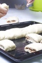 Preparation of cinnamon rolls. A woman puts buns of buns on a baking tray. Royalty Free Stock Photo