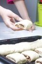 Preparation of cinnamon rolls. A woman puts buns of buns on a baking tray. Royalty Free Stock Photo