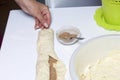 Preparation of cinnamon rolls. The woman turns off the dough with a filling of cinnamon and sugar. Royalty Free Stock Photo